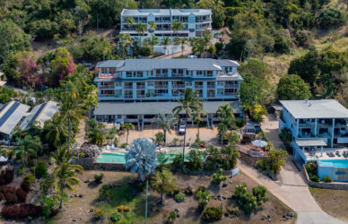 Scenic resort with ocean-view balconies, lush gardens, and a sparkling pool, perfect for a relaxing tropical getaway.