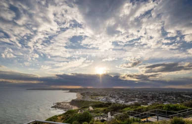 Scenic coastal view with sunset over ocean and cliffside, ideal for relaxing holidays at beachfront hotel with outdoor terrace.