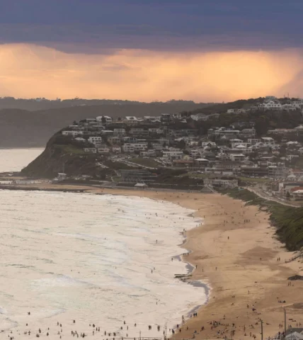 Stunning coastal view from luxurious hotel with serene beach and vibrant sunset, perfect for relaxing getaways.